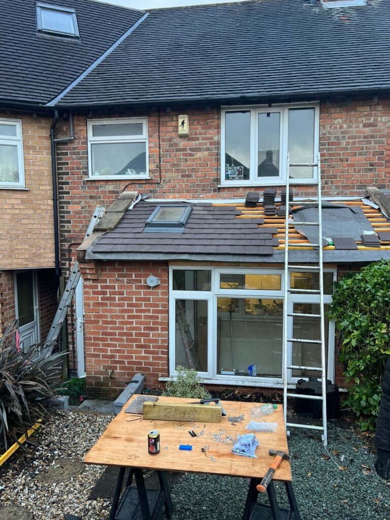 This is a photo of a roof extension that is having new roof tiles installed. This is a photo taken from the roof ridge looking down a tiled pitched roof on to a flat roof. Works carried out by Swanley Roofing Repairs