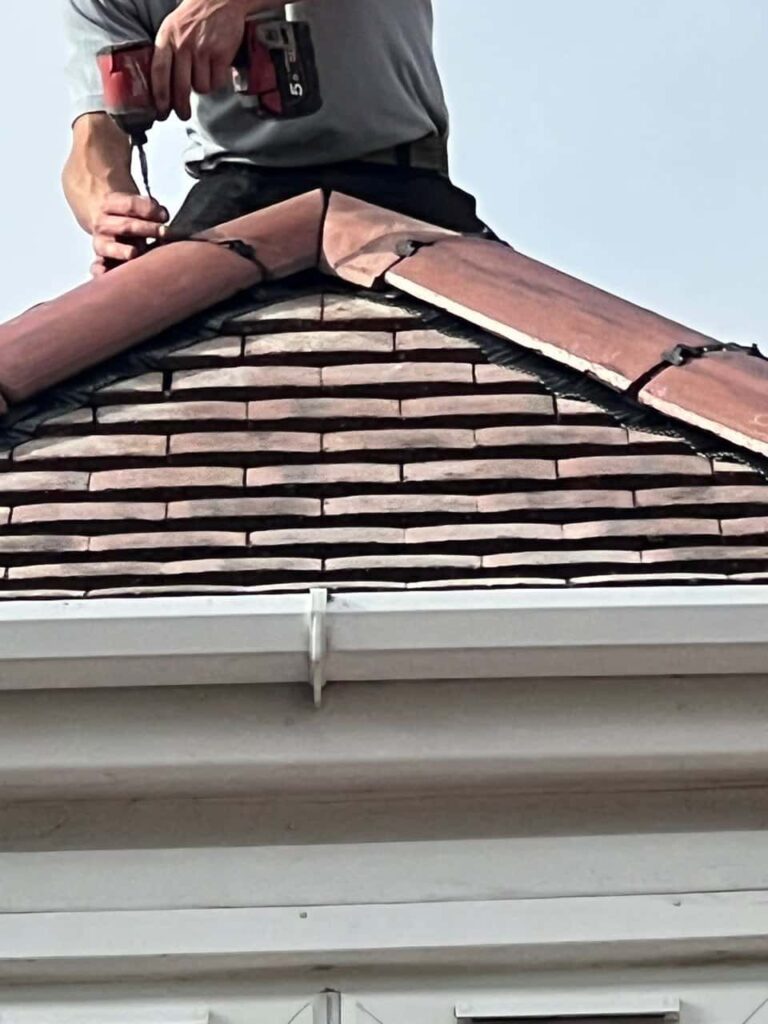 This is a photo of one of the operatives of Swanley Roofing Repairs installing new ridge tiles